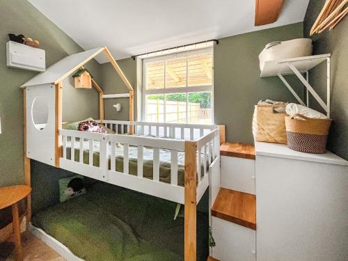 a childs room with a bunk bed and a window at The Pavillion in Dorking