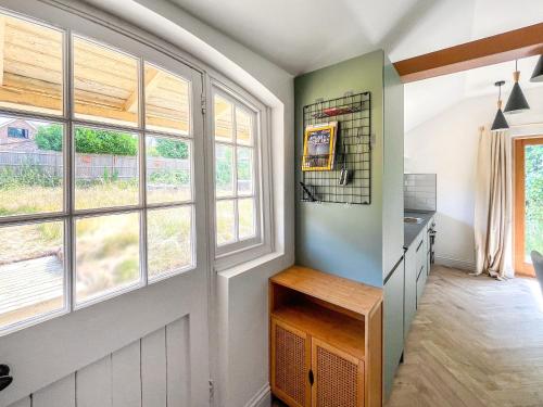 a kitchen with windows and a wooden table at The Pavillion in Dorking