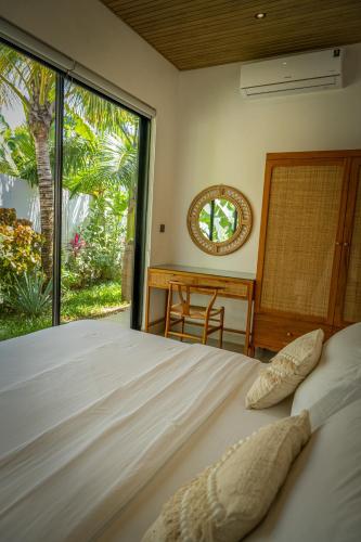 a bedroom with a bed and a desk and a window at Paje Emerald Escapes in Paje