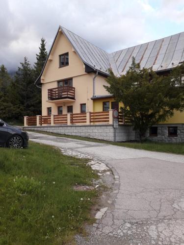 a house with a metal roof and a car parked in front at Turistické ubytovanie čiastočný suterén in Vysoké Tatry