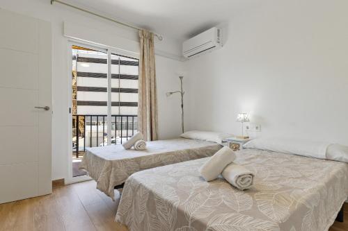 Dos camas en una habitación con ventana. en Torre Copenhague By IVI Real Estate, en Torremolinos