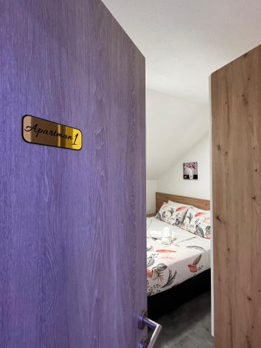 a bedroom with a purple door with a bed at Apartmani Venecia in Prozor