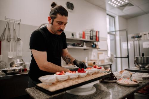 a man standing in a kitchen preparing cupcakes at Santé SPA Hotel in Velingrad