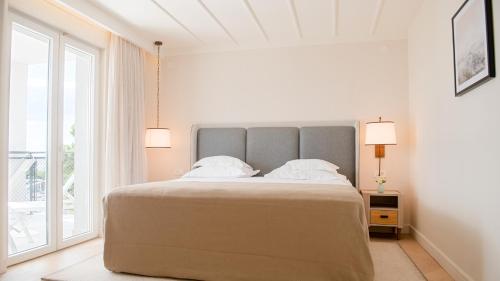 a bedroom with a large bed and a large window at Amadria Park Grand Hotel 4 Opatijska Cvijeta in Opatija