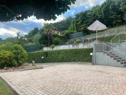a brick patio with a staircase and an umbrella at Casa Vacanza Anna in Verbania