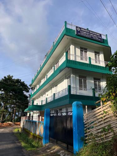 a tall building with green and white at Shanti Sojourn in Shillong