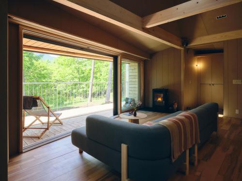 a living room with a couch and a large window at SANU 2nd Home Tateshina1st in Chino