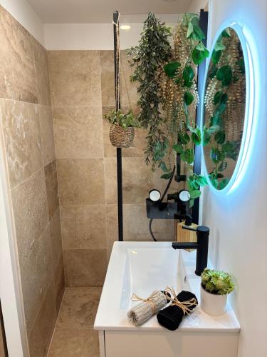 a bathroom with a white table with plants on it at Chaleureux T1 avec Balcon in Vals-les-Bains