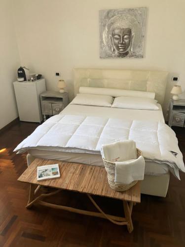 a bedroom with a large white bed and a table at Masia Mariel Playa-Adults Only in Orbetello
