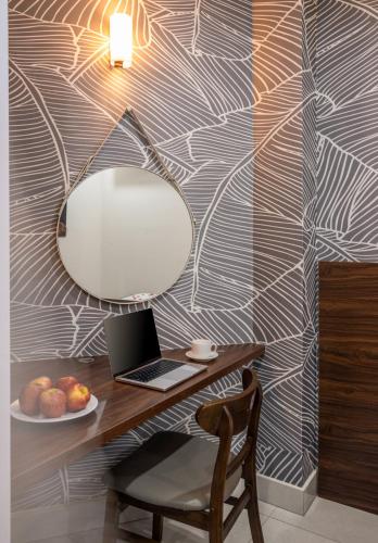 a desk with a laptop and a mirror on a wall at KLY Hotel Vung Tau in Vung Tau