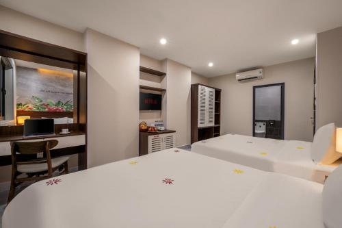 a bedroom with a large white bed and a desk at KLY Hotel Vung Tau in Vung Tau
