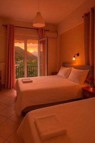 a bedroom with two beds and a window with a view at Acro Studios in Skala Potamias