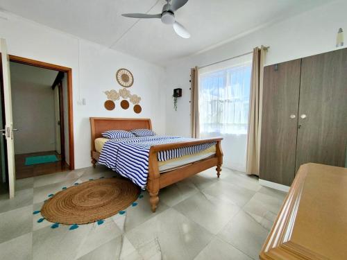 a bedroom with a bed and a ceiling fan at Noulakaz, séjour paisible à 10 min de Belle Mare in Argy
