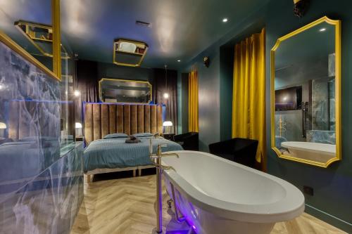 a bathroom with a tub and a bed and a bath tub at La Suite Versailles freeParking table massage Clim in Montreuil