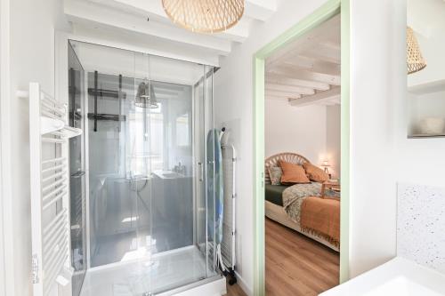 a bathroom with a walk in shower next to a bed at A Fleur de Quai - Vue sur le port in Isigny-sur-Mer