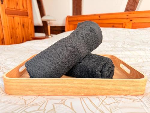 a wooden tray with black socks on a bed at Authentique Alsacien - coeur historique de Rouffach in Rouffach