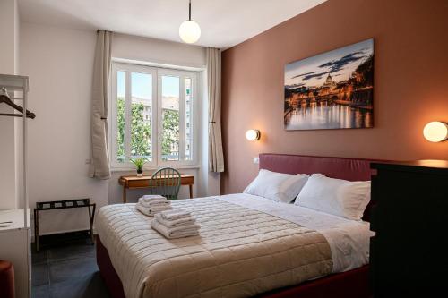 a bedroom with a large bed with towels on it at Flora Guest House in Rome