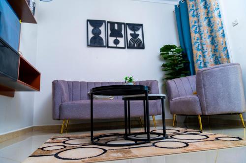 a living room with two chairs and a table at Lovana Apartments and Hotel, Gulu City in Gulu