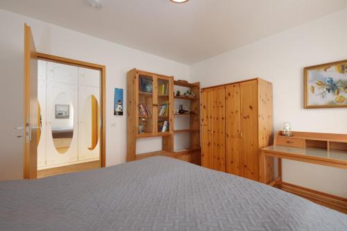 a bedroom with a bed and wooden cabinets at Villa Fördestrand Spinnaker in Laboe