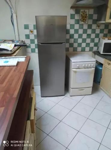 Il comprend une cuisine équipée d'un réfrigérateur et d'une cuisinière. dans l'établissement Maison chaleureuse à Ille-sur-Têt, jardin paisible, clim & cheminée, à Ille-sur-Têt