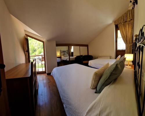 a hotel room with two beds and a mirror at Apartamentos Remoña in Espinama