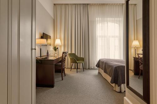 a hotel room with a bed and a desk at Elite Hotel Mollberg in Helsingborg