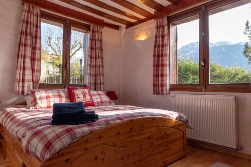 ブール・サン・モーリスにあるEntire Chalet Salamo 11 plus 1 Les Arcs Paradiski Jacuzziの窓付きのベッドルーム1室(木製ベッド1台付)