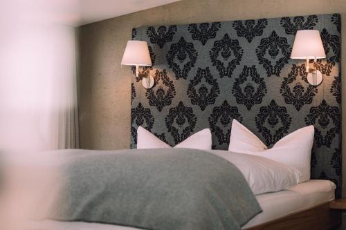 a bedroom with a bed with white pillows at Naturhotel Chesa Valisa in Hirschegg