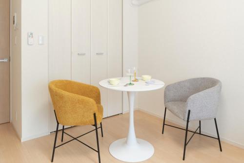a white table and two chairs in a room at J-ARC Akebonobashi in Tokyo