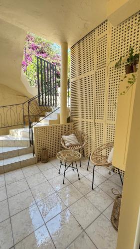 a room with chairs and tables and a staircase at Hidden Lemons - Boho stay in Rhodes in Rhodes Town