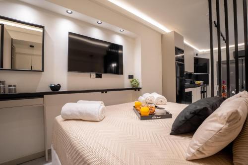 Schlafzimmer mit einem Bett und einem TV an der Wand in der Unterkunft Monte Smith Luxury Suites in Rhodos (Stadt)