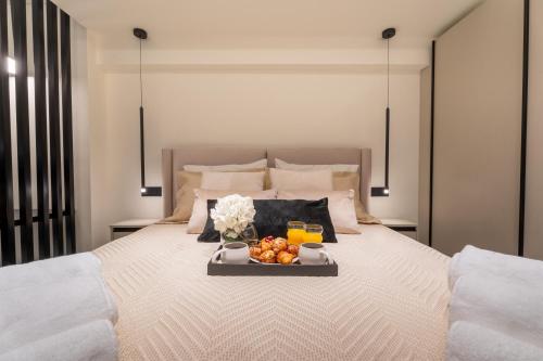 Ein Tablett mit Früchten steht auf einem Bett. in der Unterkunft Monte Smith Luxury Suites in Rhodos (Stadt)