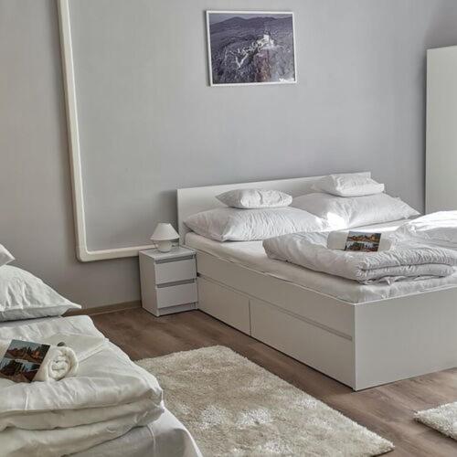 a bedroom with two beds and a mirror at Szökőkút vendégszállás in Sátoraljaújhely