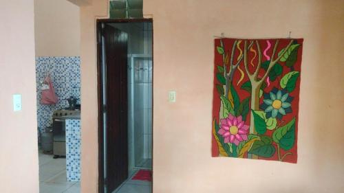 a painting of flowers on the wall of a kitchen at Casa Mar Poesia - Taiba in Taíba
