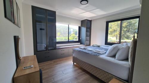 a bedroom with a bed and a large window at Orange Tree Villa, Happy Tree Houses in Dalaman