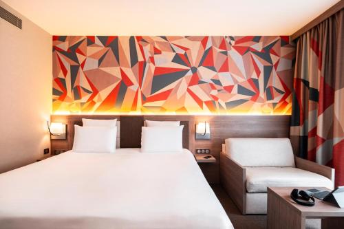 a hotel room with a bed and a couch at Mercure Bayeux Omaha Beach in Port-en-Bessin-Huppain