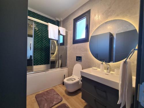 a bathroom with a toilet and a sink and a mirror at Orange Tree Villa, Happy Tree Houses in Dalaman