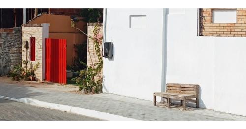 a wooden bench sitting on the side of a building at Casa Mar Poesia - Taiba in Taíba