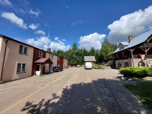 an empty street in a small town with a building at Šilainė Glamping & SPA, Padel court in Oszkinie