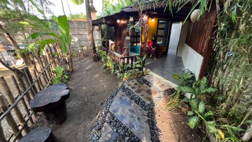 a porch of a house with a person sitting at a table at Tahlia's Villa in Sorongjukung