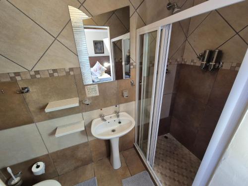 a bathroom with a sink and a shower at The Oak Potch Guesthouse in Potchefstroom