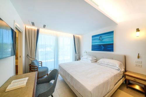 a bedroom with a bed and a table and chairs at OraBlu Exclusive Villas in Ischia