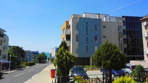a building on a street with cars parked in front at Sineva Del Sol Apartments in Sveti Vlas