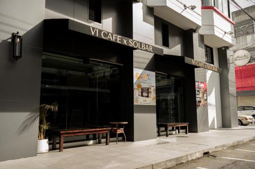 a store front of a building with benches outside at V1 boutique hotel in Kanchanaburi