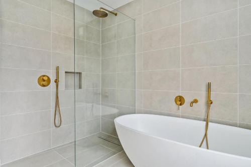 a bathroom with a tub and a glass shower at Glade House in Marlow