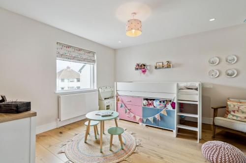 a childs room with a bunk bed and a table at Glade House in Marlow