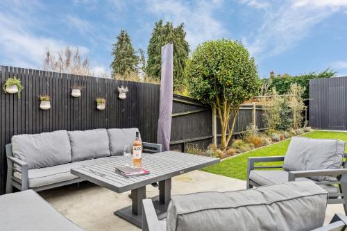 a patio with a table and chairs and a fence at Glade House in Marlow