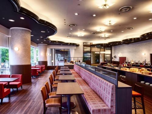 a restaurant with a long bar with tables and chairs at Royal Pines Hotel Chiba- Opening in Jan 2025 in Chiba