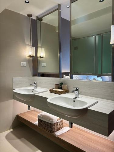 a bathroom with two sinks and a large mirror at The hotel residences at Acqua in Manila