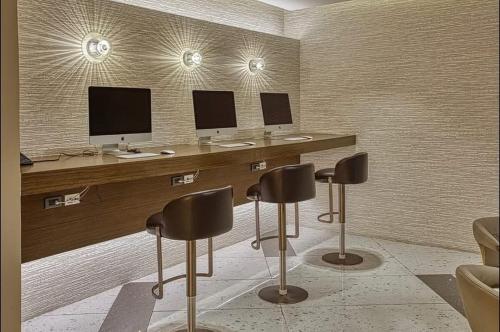 a room with three desks with three monitors and chairs at The hotel residences at Acqua in Manila